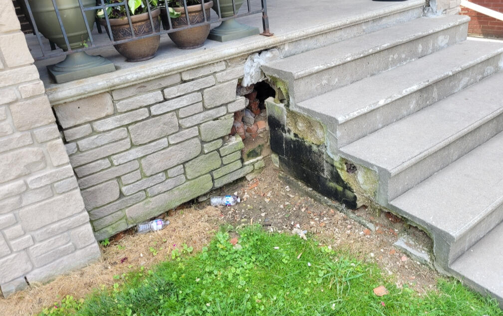 Stone masonry garden wall with limestone caps built by McNamara Masonry in Saint Clair Beach, Tecumseh, Ontario, Canada. Expert masonry services including porch restoration, brick repair, and stonework installation.